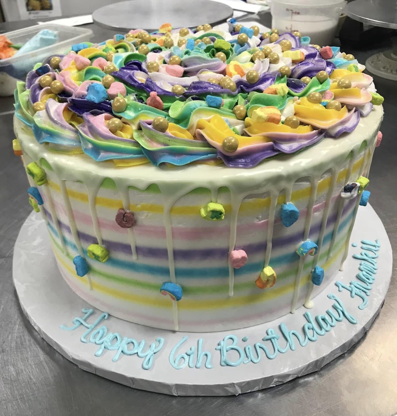 Pastel rainbow Lucky Charms birthday cake with white chocolate drip and gold pearls
