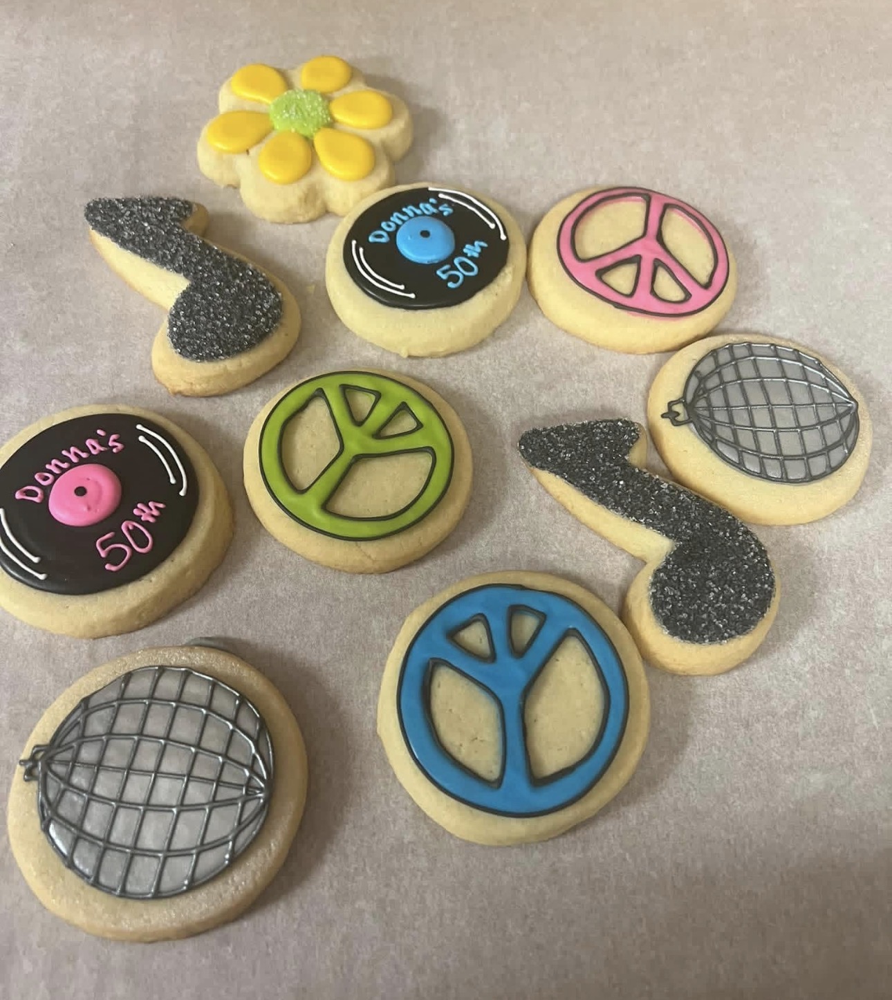70s themed 50th birthday cookies with peace signs, records, disco balls and music notes
